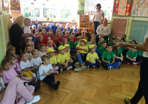 dzieci z wychowawcami w żółtych, zielonych, różowych, czerwonych i niebieskich koszulkach