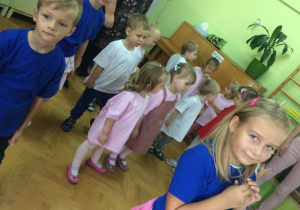 tańce i zabawy, dzieci w niebieskich, białych i różowych koszulkach