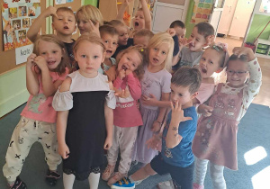 Dzieci pozują do zdjecia z koleżanką, która ma urodziny