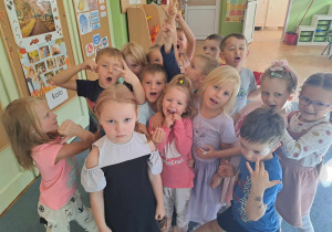 Dzieci pozują do zdjecia z koleżanką, która ma urodziny