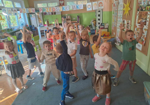 Dzieci tańczą na dywanie do piosenki urodzinowej