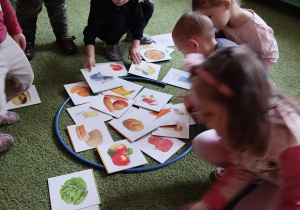 Dzieci wkładaja do obręczy zdrowe produkty.