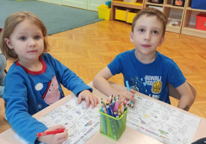 Dziewczynka i chłopiec kolorują.