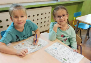 Dziewczynka i chłopiec kolorują.