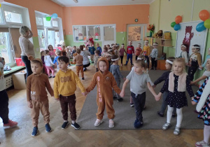 Dzieci tańczą na balu w strojach misów