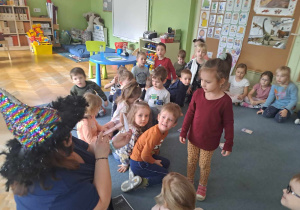 Nauczycielka podświetla latarką kartę i odczytuje znaczenie symbolu