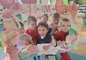 Chłopcy pozują do zdjęcia w walentynkowej foto ramce