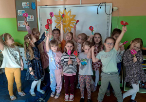 Dziewczynki pozują do zdjęcia z prezentami od kolegów z okazji Dnia Kobiet