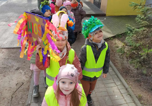 Dzieci maszerują po okolicy z transparentami witając wiosnę