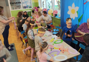 Dzieci z rodzicami/opiekunami tworzą ozdoby wielkanocne