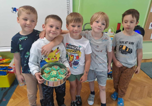 Chłopcy pozują do zdjęcia z kolegą który ma urodziny