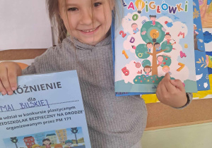 Dziewczynka prezentuje do zdjęcia dyplom i nagrody, które zdobyła w konkursie