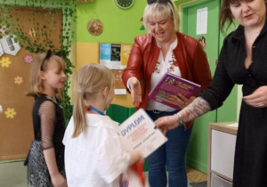 Dziewczynki odbierają nagrody i dyplomy.