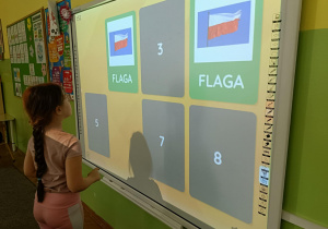 Dziewczynka otworzyła dwie karty w grze memory z symbolem Polski-flagą.