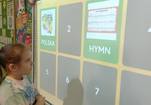 Dziewczynka otworzyła dwie karty w grze memory. Na jednej z nich widać mapę Polski a na drugiej hymn Polski.