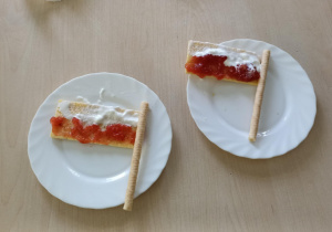 Na białym talerzyku przygotowany poczęstunek (biało-czerwone flagi).