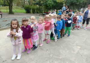 Dzieci stoją w pociągu i machają do zdjęć.