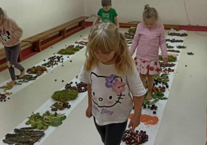 Czwórka dzieci chodzi po ścieżce sensorycznej.