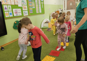Dzieci spacerują po kolorowej ścieżce.