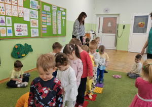 Dzieci spacerują po kolorowej ścieżce.