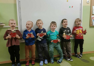 Szóstka chłopców stoi na tle białej tablicy. W rękach trzymają skończone prace.