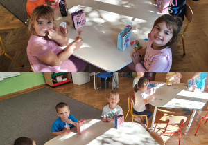 Dzieci siedzą przy stolikach i pozują do zdjęcia