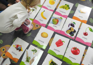 Na dywanie leżą plansze z jedzeniem. Dzieci siedzą wokół.Na dywanie leżą plansze z jedzeniem. Dzieci siedzą wokół.