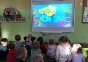 Dzieci oglądają bajkę o rybce.