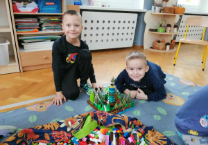 Dwóch chłopców pozuje ze skończoną budowlą.