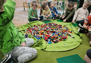 Szóstka dzieci siedzi wokół worka.