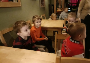 Na zdjęciu szóstka dzieci patrzy przed siebie. Jeden z chłopców uśmiecha się do zdjęcia.