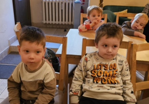 Dwóch chłopców siedzi przy stoliku. W tle widać dzieci siedzące przy innych stolikach.