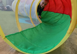 Chłopiec przechodzi przez kolorowy tunel.