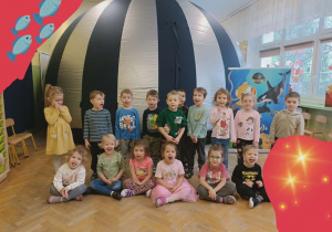 Grupa dzieci stoi na tle kopuły.