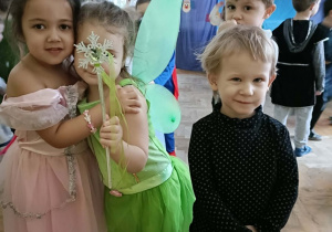 Trzy dziewczynki i jeden chłopiec uśmiechają się do zdjęcia.