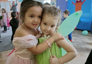 Dwie dziewczynki uśmiechają się do zdjęcia.