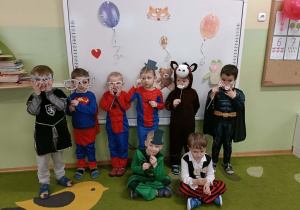 Grupa chłopców na tle dekoracji. W rączkach trzymają gadżety do fotobuduki.