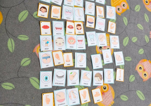 Na dywanie w sowy leżą karty.