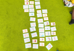 Na zielonym dywanie leżą karty.