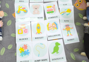 Na dywanie w sówki leżą kolorowe karty.