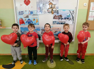 Pięciu chłopców pozuje do zdjęcia z balonami w dłoniach.