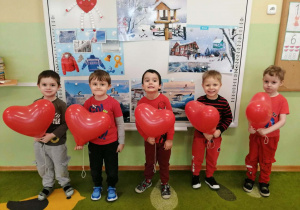 Pięciu chłopców pozuje do zdjęcia z balonami w dłoniach.