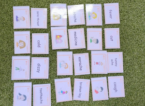 Na zielonym dywanie leżą kolorowe karty.