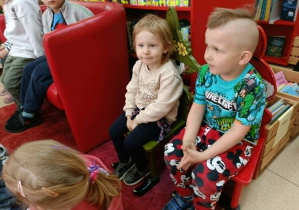 Dziewczynka i chłopiec siedzą na krzesełkach.