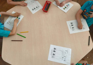 Dzieci wypełniają karty pracy.
