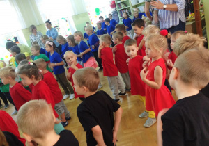 tańce i zabawy, na zdjęciu dzieci w czerwonych i niebieskich koszulkach