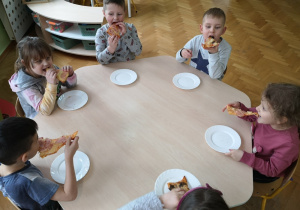 dzieci jedzą pizzę