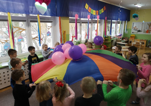 dzieci podrzucają balony na chuście animacyjnej