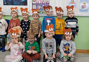 Grupa dzieci pozuje do zdjęcia z pluszowymi misiami, na głowach dzieci mają opaski z misiem