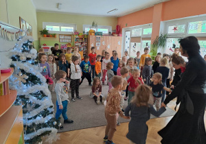 Grupa dzieci tańczy na dywanie do świątecznych piosenek